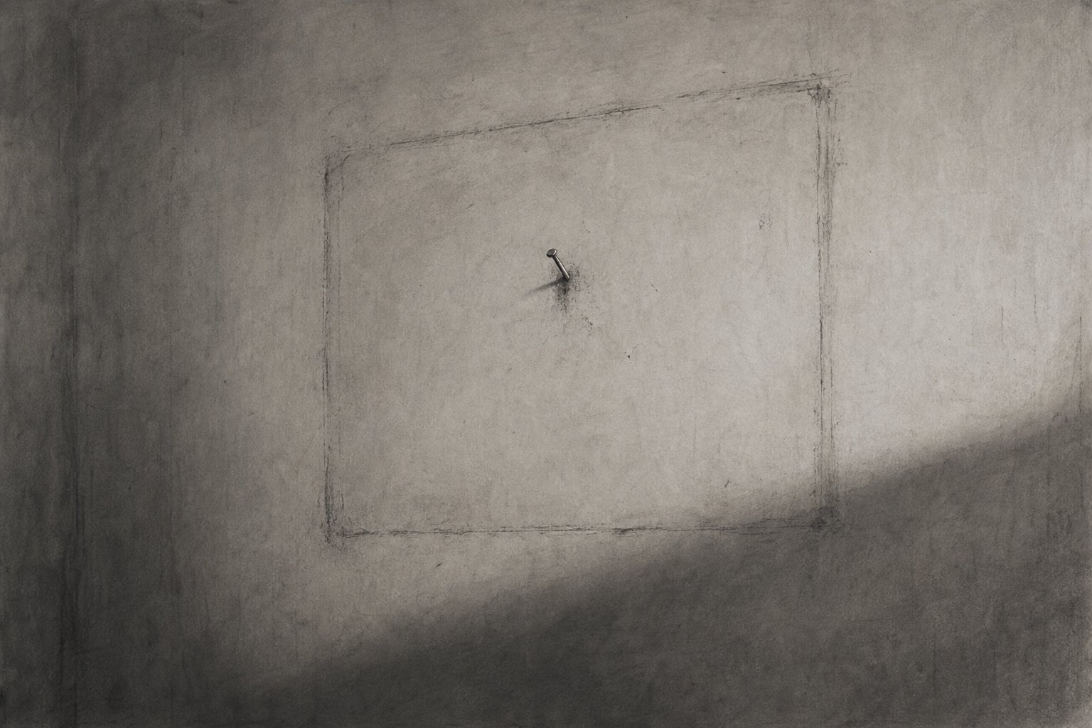 An empty wall with the faint outline and single nail where a frame used to hang